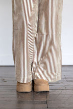 Load image into Gallery viewer, Striped pants and tan shoes on a wooden floor with a white wall background
