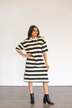 Load image into Gallery viewer, Woman wearing a black and white striped dress with a plain background
